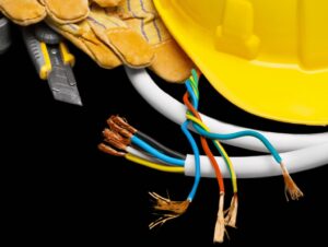 electrical contractor supplies, including a hard hat, gloves, utility knife, and electrical wires