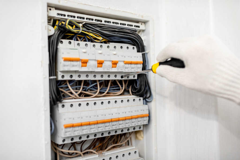 close up of an electrician installing or repairing apartment electrical panel