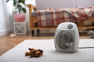 space heater on a table next to a stuffed animal