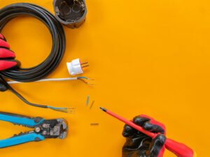 Electrician tools on orange background.