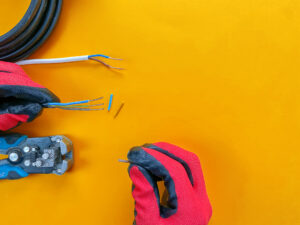 Electrician tools on orange background with copy space for text. Photos for the workshop and the store of building materials. Selective focus.