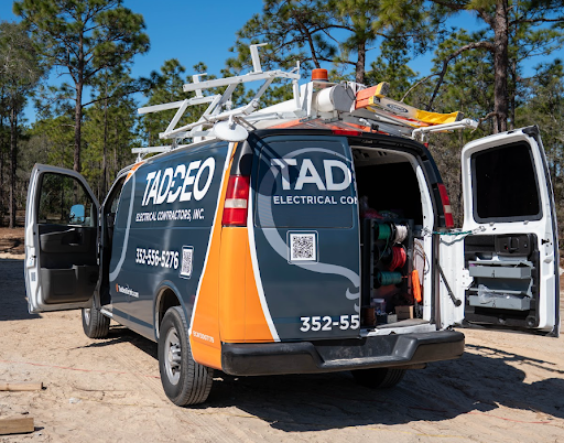 Taddeo Electrical Contractors service van with open doors and electrical supplies at a Florida job site, ready for a residential panel upgrade